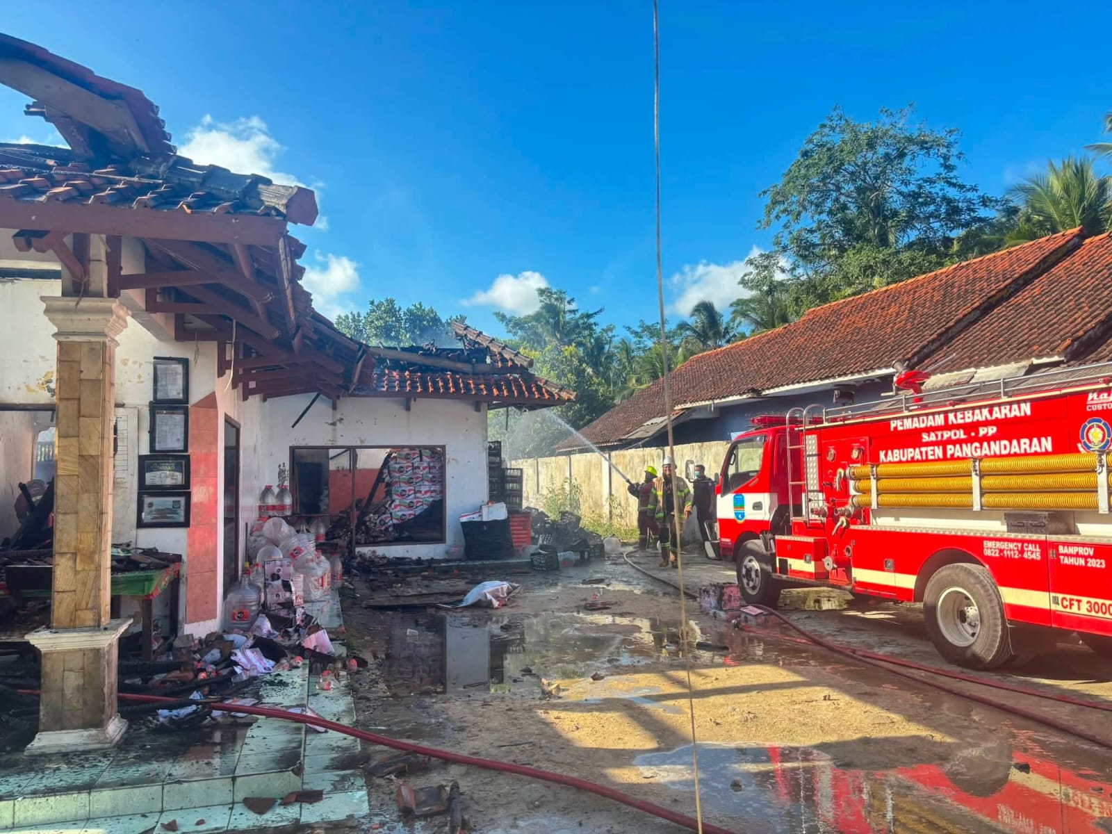 Petugas Damkar melakukan proses pendinginan setelah berhasil memadamkan kebakaran gudang penyimpanan air minum kemasan di Desa Sukaresik, Pangandaran.